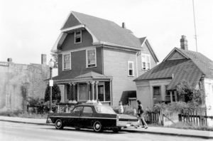 1968 Hogan's Alley, two houses and a dark car