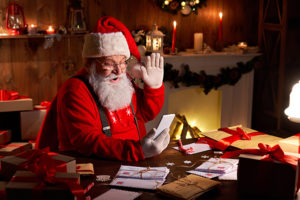 Santa waving at his phone for a virtual holiday celebration